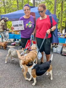 Compassion in Action: Over 200 Pets Served at Newton County Outreach Event 5 Two residents with their dogs and a sign that says, "thank you. "